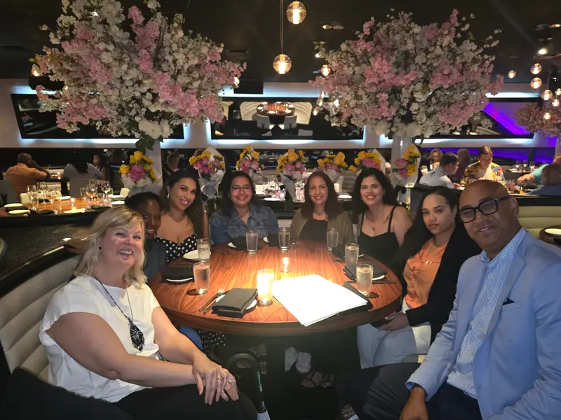 Alexander Perez sitting with AMP team members around a dinner table